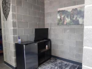 a black refrigerator in a room with a brick wall at Moderno Departamento Ejecutivo frente a Explanada in Pachuca de Soto