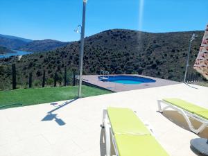 a patio with two chairs and a swimming pool at Quinta Flor Dos Lagos - Eco Tiny Hause in Torre de Moncorvo