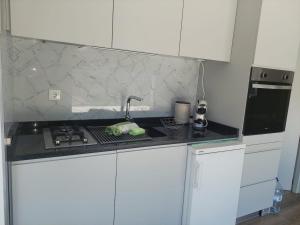 a white kitchen with a stove and a sink at Quinta Flor Dos Lagos - Eco Tiny Hause in Torre de Moncorvo