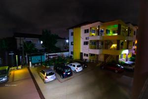 a group of cars parked in a parking lot in front of a building at Cozy Luxury - East Legon Apt - WiFi, Netflix & AC in Accra