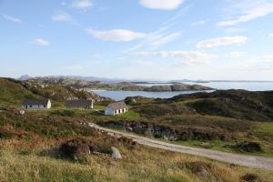 a house on a hill next to the ocean at Heather Cottage in Lairg