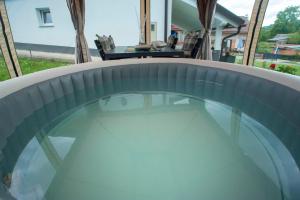 a plunge pool in a backyard with a table at Apartman Rita in Slunj
