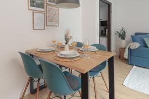 a dining room table with blue chairs in a living room at Cozy Bergzeit 230 - Mountain View, Stylish, Familyfriendly in Bad Goisern
