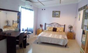 a bedroom with a bed and a desk in it at sleepy hollow guesthouse in Pantai Cenang +13 photos