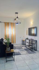 リーブルヴィルにあるMaison La Luciole LOUISのソファとテーブルのあるリビングルーム
