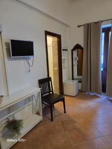 a living room with a chair and a tv on the wall at Nostra casa rooms in Palermo