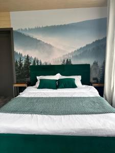 a bedroom with a large bed with a green headboard at N V New View in Yaremche