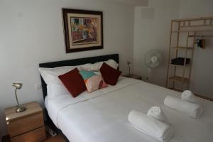 a bedroom with a large white bed with towels on it at Les Loriots in Laredorte