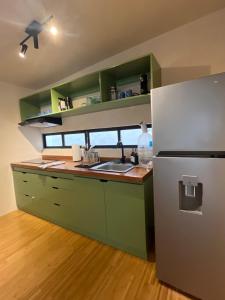a kitchen with green cabinets and a refrigerator at Casa Yag in Brisas de Zicatela
