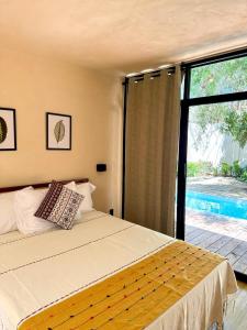 a bedroom with a bed and a large window at Casa Yag in Brisas de Zicatela