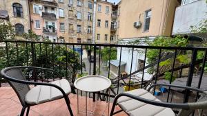 a balcony with a table and chairs and buildings at Boomerang Apartments in Odesa