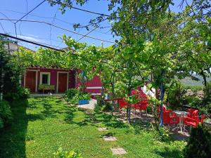 ein Garten mit roten Stühlen und einem Tisch in der Unterkunft SuperPanorama GuestHouse in Kukës + 71 Fotos