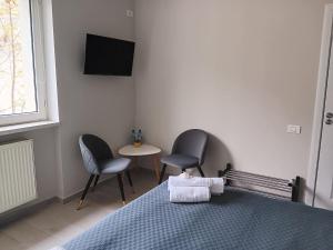 a bedroom with two chairs and a table and a bed at Dulce Luna in Bucharest