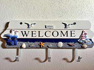 un panneau qui dit bienvenue avec des oiseaux dessus dans l'établissement La Casetta di Lally, à Cabras