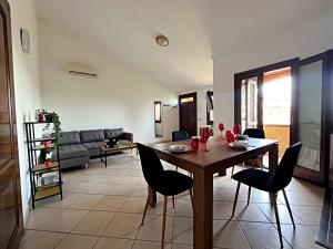 un salon avec une table et des chaises en bois dans l'établissement La Casetta di Lally, à Cabras 12 autres photos