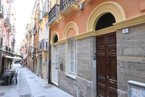 een steegje met een houten deur op een gebouw bij The Lemon House in Cagliari