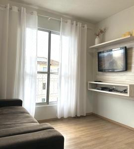 Μια τηλεόραση ή/και κέντρο ψυχαγωγίας στο Apartamento Agradável próximo ao aeroporto