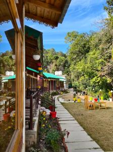 a building with a garden next to a street at Bhimtal Birding Lodge in Bhowāli