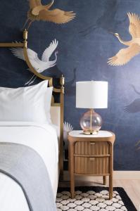 a bedroom with a bed and a table with a lamp at The Milo in Santa Barbara