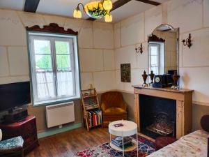 un soggiorno con camino e TV di Le Jardin Yuccas - Cosy cottage in the Loir& Loire Valleys a La Chapelle-aux-Choux