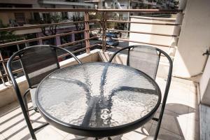 Una mesa de cristal y sillas en un balcón. en VPG Minimal Studios Traveller3, en Tesalónica
