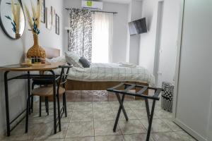 Un dormitorio con una cama y una mesa y sillas. en VPG Minimal Studios Traveller3, en Tesalónica
