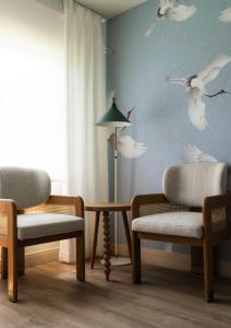 a room with two chairs and a table with birds on the wall at The Milo in Santa Barbara
