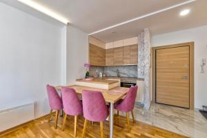 a kitchen with a wooden table and purple chairs at Vip Bogic 58 in Zlatibor +3 photos