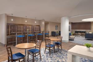 a lobby with tables and chairs and a bar at The Lodge at Duke Medical Center in Durham