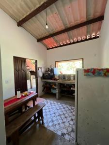 a living room with a table and a refrigerator at Casa de Deli in Ilha de Boipeba