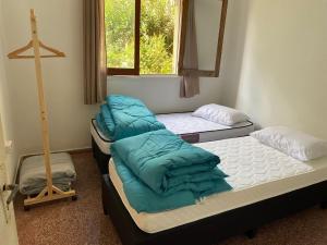 two beds sitting in a room with a window at Petit Olimar in Treinta y Tres