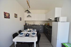 a kitchen with a table and a white refrigerator at Casa Laita in Sarego