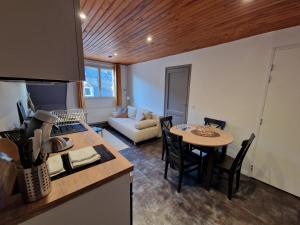 a kitchen and living room with a table and a couch at La Barroude in Bagnères-de-Bigorre +37 photos