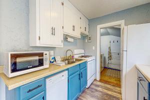 una cucina con armadi blu e frigorifero bianco di River Beach Cottage a Bellaire
