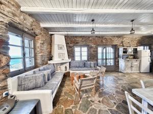 a living room with couches and a stone wall at The Traditional Stone Villa in Koundouros