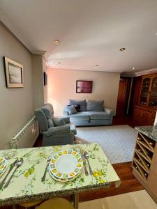 a living room with a table and a couch at Gestiona2R - Apartamento para dos céntrico en Nueva de Llanes in Nueva de Llanes +16 photos
