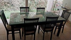 a dining room table with four chairs and a glass table and chairs at Salmanel Resort Ayagama - Rathnapura in Ratnapura