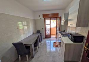 a kitchen with a wooden table and a counter top at House Riky in Assemini +6 photos