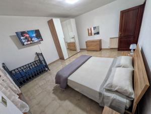 a bedroom with a bed and a tv on the wall at House Riky in Assemini