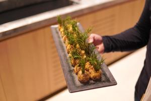 a person holding a tray of food on a counter at DoubleTree by Hilton Caracol Canela in Canela