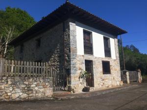 a stone house with a gate and a fence at Ribera del Sella III in Dego