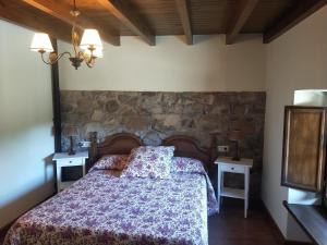 a bedroom with a bed with a stone wall at Ribera del Sella III in Dego