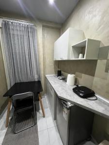 a small kitchen with a counter and a black chair at City Corner Stay in Kavala