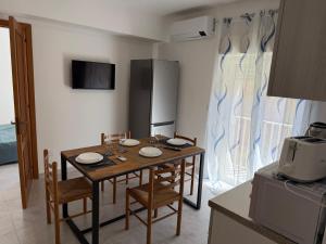 een keuken met een houten tafel met stoelen en een magnetron bij FAMILY HOUSE Letojanni Taormina in Letojanni