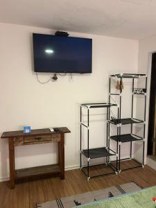 a room with a desk and a tv on a wall at Canoa Ilha Grande in Abraão