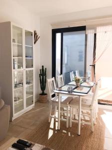 a dining room with a white table and chairs at Casa Alegria Penthouse in Corvera