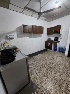 a kitchen with a counter and a refrigerator in a room at Mochila Urban1 in San Salvador
