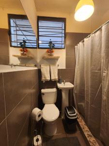 a bathroom with a toilet and a sink at Mochila Urban1 in San Salvador +46 photos