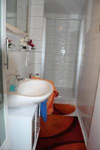 a white bathroom with a sink and a shower at Wunderschönes Ferienhaus In Zainingen in Zainingen
