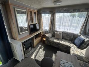 an rv living room with a couch and a tv at Holiday Caravan in Clacton-on-Sea